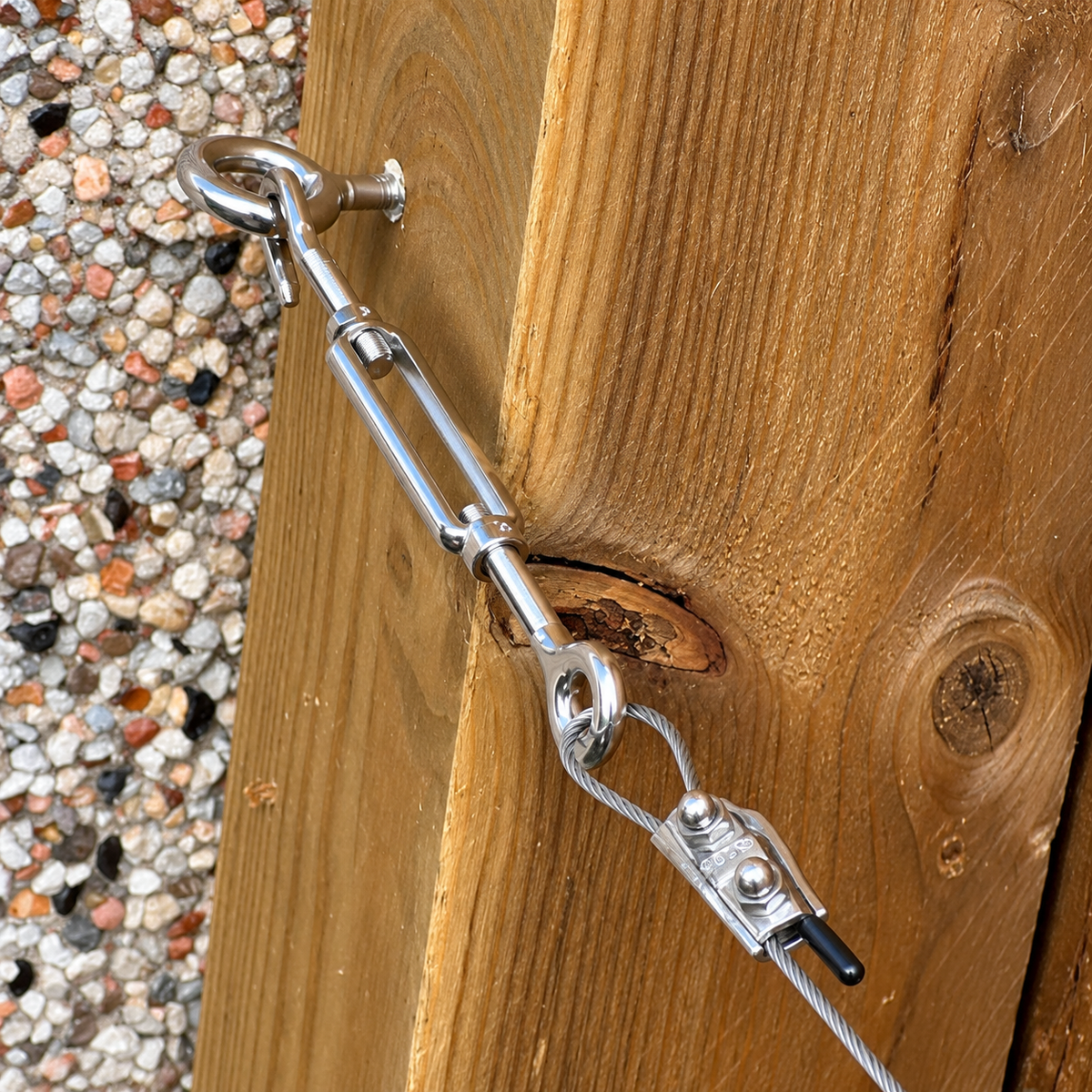 Photo of a stainless steel turnbuckle installed on weathered wood showing all the trellis components installed altogether