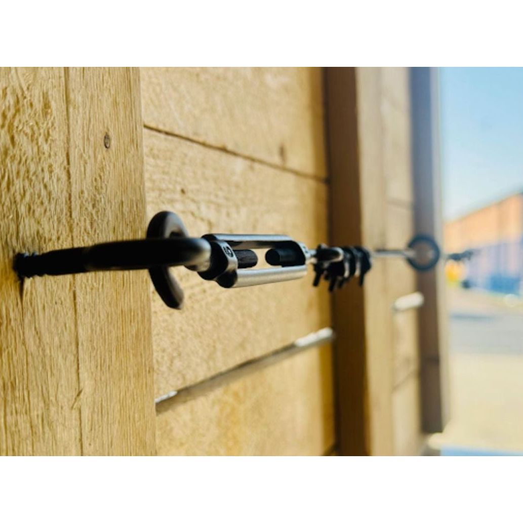 Close-up of TECNI BLACK Trellis system on a wooden fence with blurred background