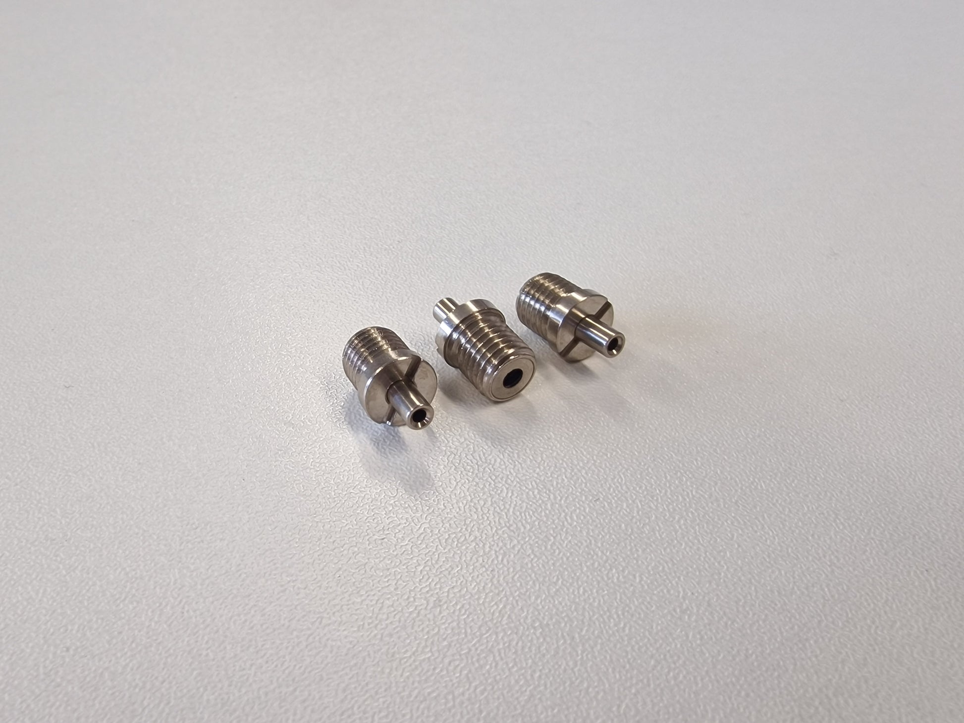 Three Metallic TECNI cable Grippers on a white table 170.012.002