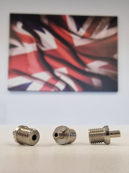 Three Metallic TECNI cable Grippers on a white table with a blurred union jack background 170.012.002