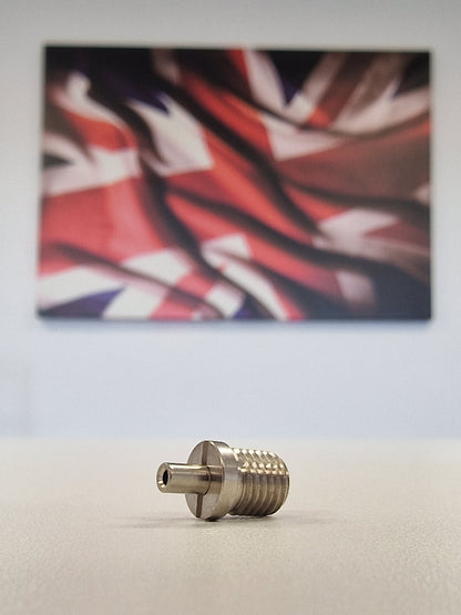Metallic TECNI cable Gripper on a white table with a blurred union jack background 170.012.002