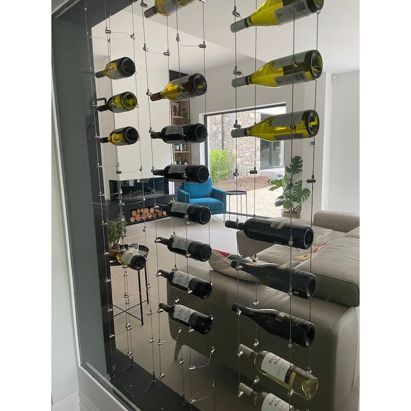 DIY Wine Rack System. Metallic tension grippers holding wire rope cables in front of a window as part of a wine rack system in a home 170.025.004