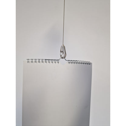 Metallic Hook Gripper on wire rope holding a calendar on a white background