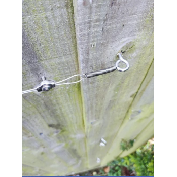 TECNI Micro Trellis system 0.7mm with spring tensioner on wooden fence panel
