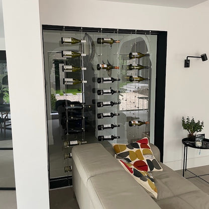 Metallic tension grippers holding wire rope cables on a black floor in a window as part of a wine rack system in a home 170.025.004
