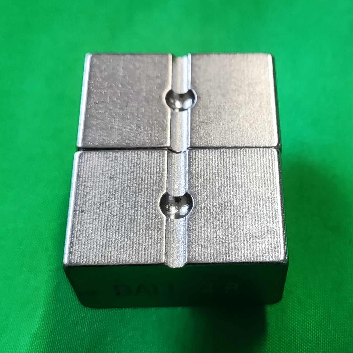 photo of a ball die set put together on green background showing the top view. 